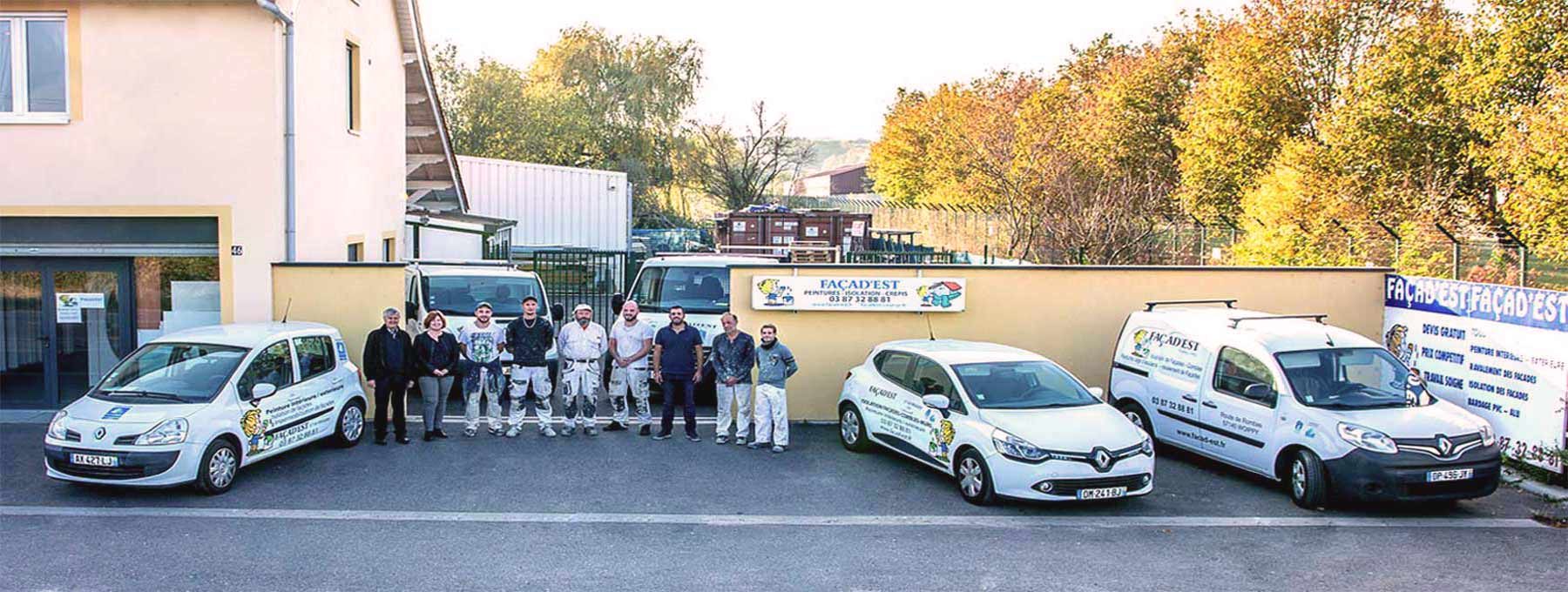 L'équipe Façad'Est en tenue de peintre devant le dépôt de Woippy, avec les véhicules floqués